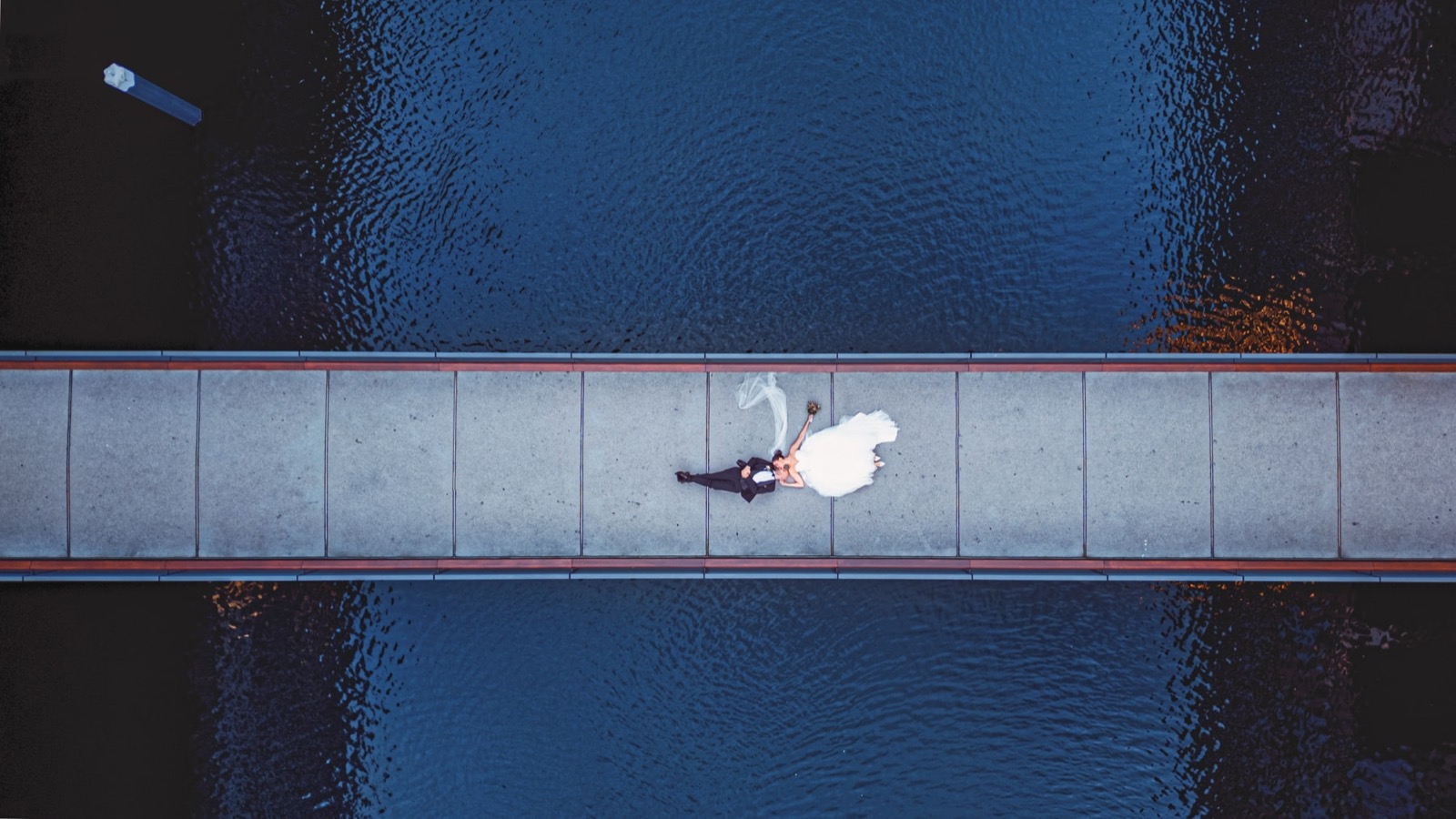 Drohnenaufnahme Brautpaar auf Brücke über dem Wasser