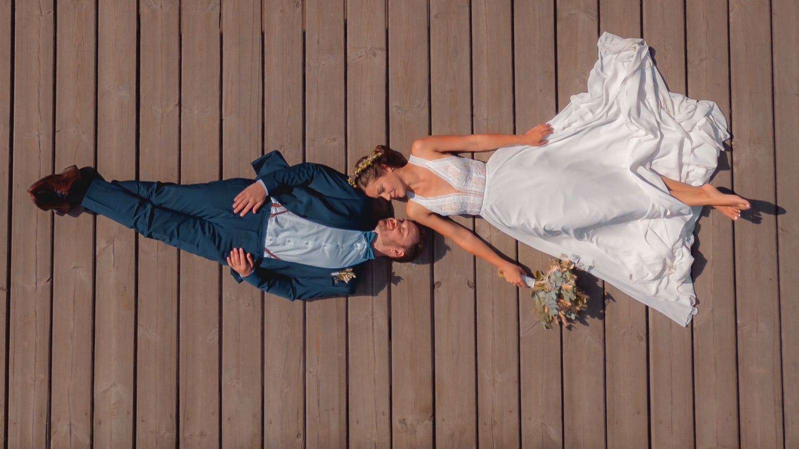 Brautpaar Kopf an Kopf auf Holzsteg von oben – Hochzeitsfotograf Hamburg
