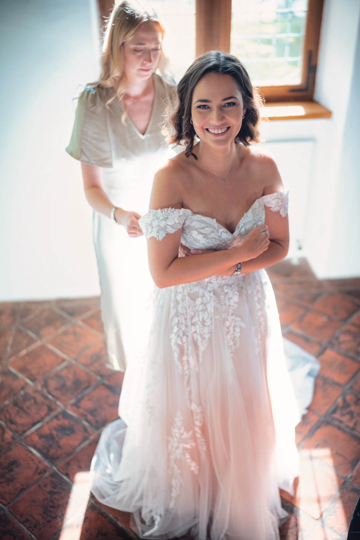 Braut beim Getting Ready – Kleid wird geschnürt