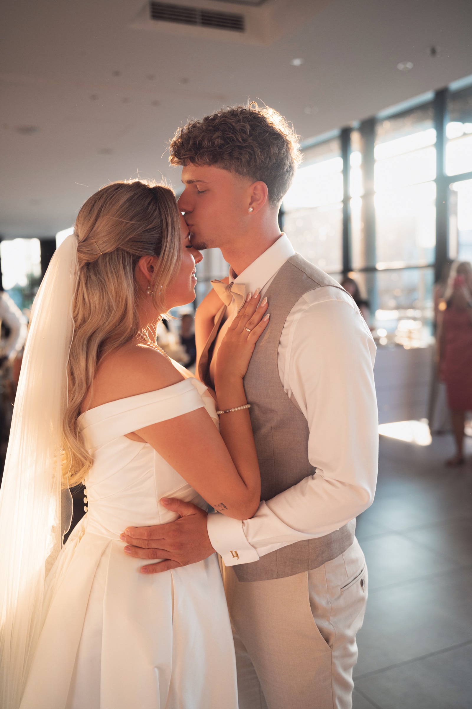 Zärtlicher Kuss auf die Stirn der Braut